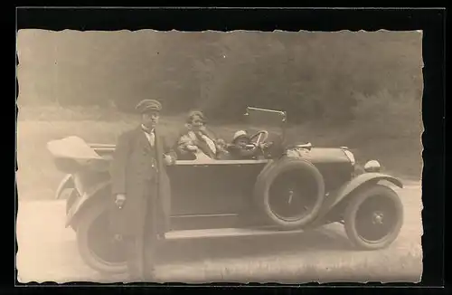 Foto-AK Glückliches Kind darf am Steuer eines Autos sitzen, Fahrer neben Auto