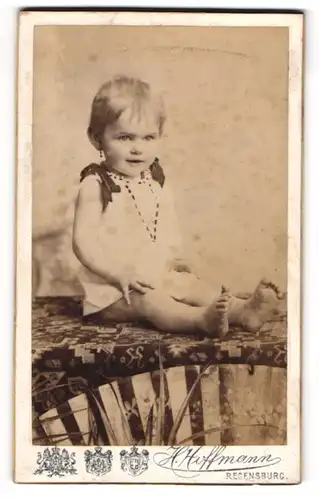 Fotografie H. Hoffmann, Regensburg, Jesuitenplatz, Kleinkind im kurzen Kleidchen auf einem Tisch
