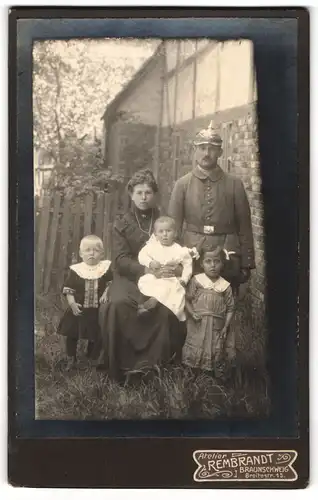 Fotografie Atelier Rembrandt, Braunschweig, Breitestrasse 15, Soldat mit Pickelhaube in Feldgrau mit Frau und Kindern