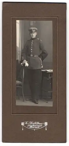 Fotografie K. Mühlbauer, Neubreisach-Breisach, Soldat in Uniform mit Schirmmütze, Portepee und Bajonett