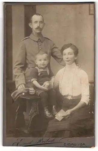 Fotografie Emil Roitsch, Eibau, vis-a-vis Gasthaus z. Hirsch, Soldat in Feldgrau mit Segelohren nebst Frau und Kind