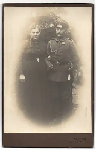 Fotografie Louis Grönig, Bad Grund i. H., Gestandener Soldat mit Schützenschnur und Säbel mit seiner Gattin