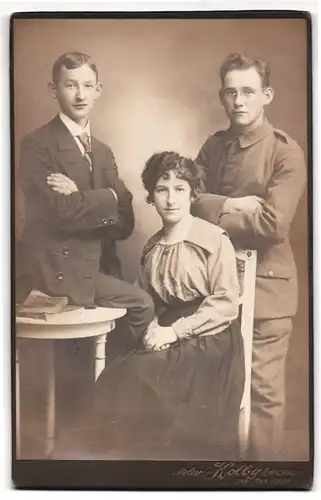 Fotografie Atelier Kolby, Zwickau i. S., Soldat mit Brille in Feldgrau mit seinen Geschwistern
