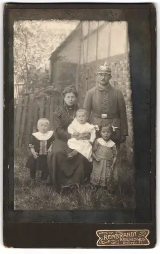Fotografie Atelier Rembrandt, Braunschweig, Breitestrasse 15, Soldat mit Pickelhaube in Feldgrau mit seiner Familie