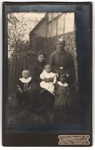 Fotografie Atelier Rembrandt, Braunschweig, Breitestrasse 15, Soldat mit Pickelhaube in Feldgrau mit seiner Familie