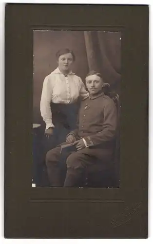 Fotografie Atelier Paulsen, Lübeck, Breitestrasse 41, Unteroffizier mit Orden in Uniform neben seiner Gattin