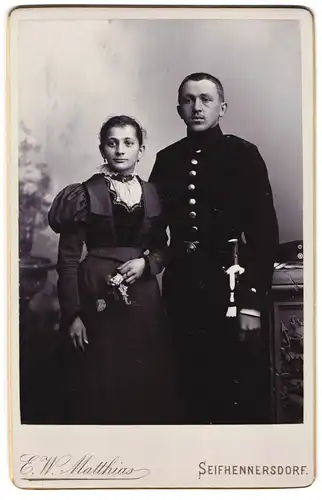 Fotografie E. W. Matthias, Seifhennersdorf, Junger Soldat in Uniform mit Säbel und Portepee und seiner Angetrauten