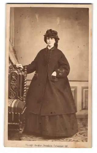 Fotografie J. Gaukler, Stuttgart, junge Frau im dunklen Kleid mit Wintermantel und Hut