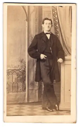 Fotografie Ernst Tanneberg, Genthin, junger Mann im dunklen Anzug vor einer Studiokulisse
