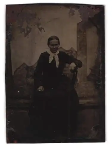 Fotografie Ferrotypie ältere Dame im dunklen Kleid vor einer Studiokulisse