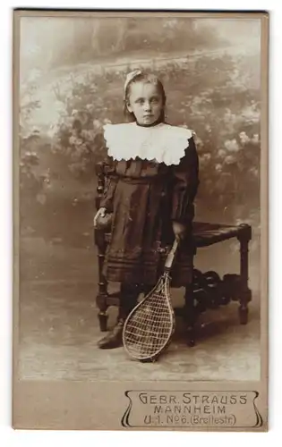 Fotografie Gebr. Strauss, Mannheim, Breitestr. 6, Hübsches Mädel im schwarzen Sonntagsgewand mit Tennisschläger
