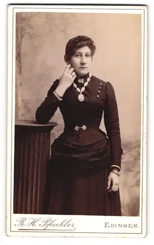 Fotografie R. H. Pfaehler, Ebingen, Silberburgstr, Junge Dame mit grossen Ohren und gelocktem Haar im schwarzen Kleid