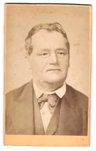 Fotografie E. Herold, Plauen i./V., Bahnhofstrasse 42, Älterer Herr mit Brille im schwarzen Anzug und Fliege