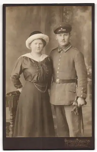 Fotografie Hermann Böbers, Berlin-Neukölln, Saalestrasse 1, Uffz. in Uniform mit Portepee und Frau an seiner Seite