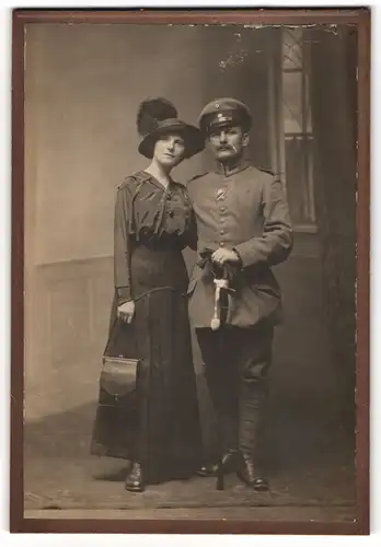 Fotografie unbekannter Fotograf und Ort, Gestandener Uffz. in Uniform mit Orden und Säbel nebst seiner Gattin
