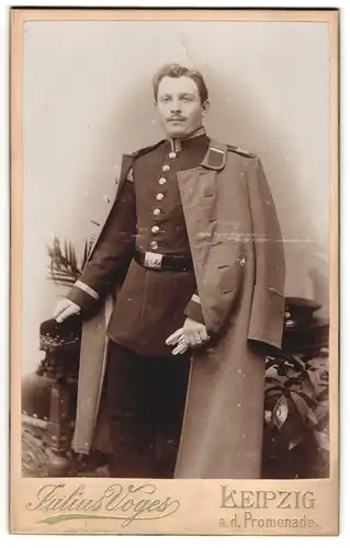 Fotografie Julius Voges, Leipzig, a.d. Promenade, Unteroffizier in Uniform mit Mantel und Handschuhen, IR 107