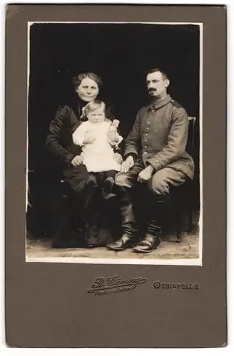 Fotografie R. Göring, Oebisfelde, Gestandener Soldat in Uniform mit Frau und Kind