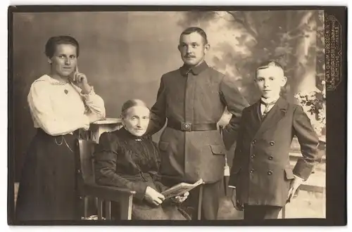 Fotografie unbekannter Fotograf und Ort, Soldat in Feldgrau mit Bajonett mit Familie