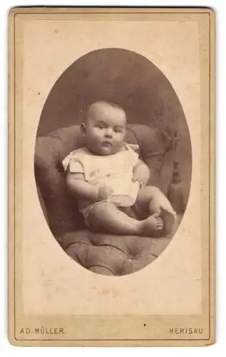 Fotografie Ad. Müller, Herisau, Casernenstr., Pausbäckiger Säugling im weissen Kleidchen sitzt auf Stuhl