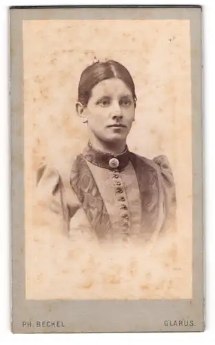 Fotografie Ph. Beckel, Glarus, Schöne junge Dame mit gebundenem Haar im hochgeschlossenen Kleid
