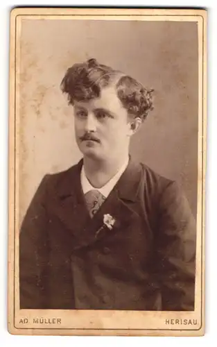 Fotografie Ad. Müller, Herisau, Junger Herr mit Schnurrbart und lockigem Haar in schwarzem Anzug