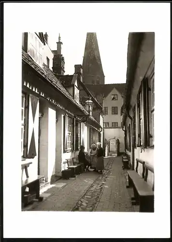 Fotografie Walter Wasssner, Lübeck, Ansicht Lübeck, Gasse mit Kirchturm im Hintergrund