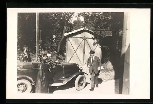 Foto-AK Auto an einem Schuppen, daneben Ausflügler