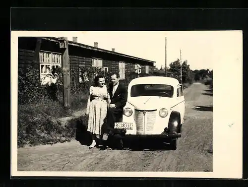 Foto-AK Auto Opel mit Besitzerpaar vor einer Baracke