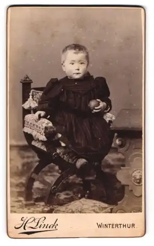 Fotografie H. Linck, Winterthur, St. Georgenstrasse, Kind im gestreiften Kleid mit einem Ball
