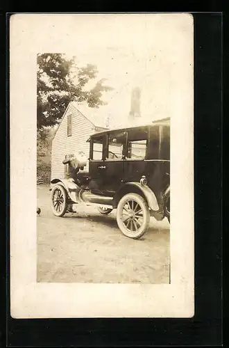 Foto-AK Auto mit jungem Mann beim Nachfüllen von Kühlwasser vor einem Haus