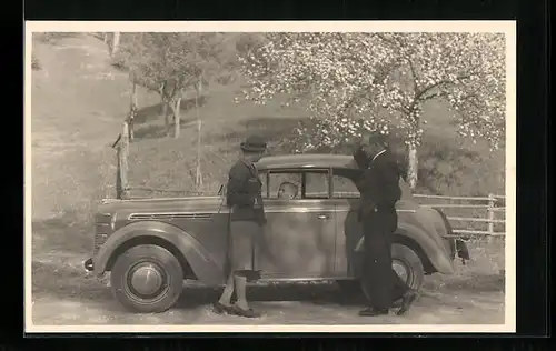 Foto-AK Auto, Opel-Kadett an einem Wiesenstück, daneben Ehepaar