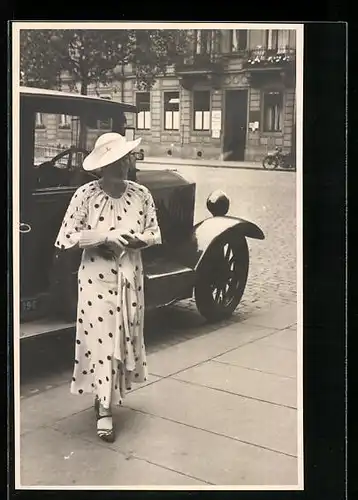 Foto-AK Auto, davor ein Dame in gepunktetem Kleid