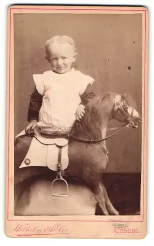 Fotografie Wilhelm Adler, Coburg, kleines Kind mit Schaukelpferd im Atelier