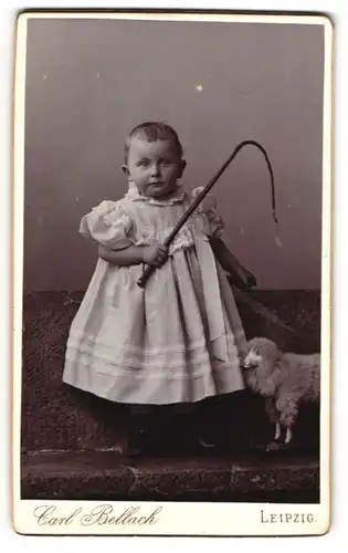 Fotografie Carl Bellach, Leipzig, kleines Mädchen im Kleid mit Stoffschaf und Peitsche