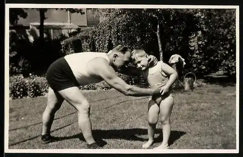 Fotografie Vater und Sohn beim Ringen im Garten, Ringkampf