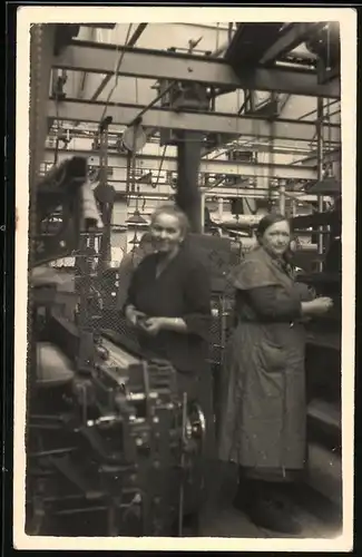 Fotografie Fabrikarbeiterinnen bestücken Fertigungsmaschinen in einer Fabrik