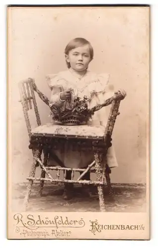 Fotografie R. Schönfelder, Reichenbach i. V., Zwickauerstr. 42, Kleines hübsches Mädchen posiert hinter einem Stuhl