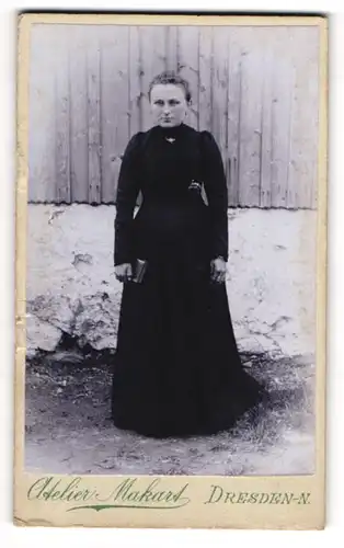 Fotografie Atelier Makart, Dresden, Bautznerstrasse 29, Ernst blickende Frau in einem schwarzen Kleid