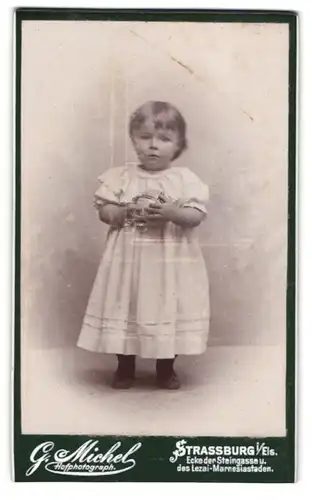 Fotografie G. Michel, Strassburg i./Els., Niedliches Kleinkind im weissen Kleidchen mit Ball in den Händen