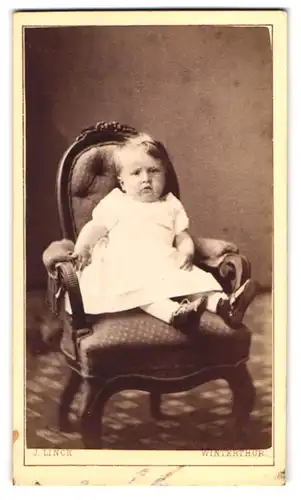 Fotografie J. Linck, Winterthur, Niedliches Kleinkind auf Stuhl sitzend im weissen Kleidchen