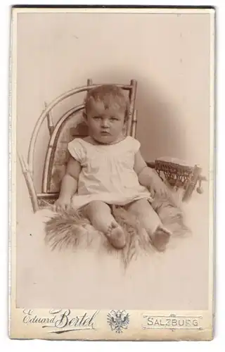 Fotografie Eduard Bertel, Salzburg, Kleinkind im weissen Kleidchen auf einem Stuhl sitzend