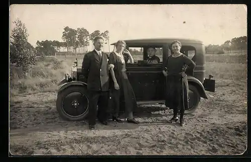 Foto-AK Opel, Auto mit Fahrer und Menschen daneben