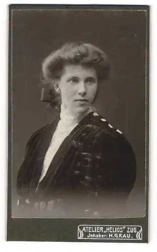 Fotografie Atelier Helios, Zug, Hübsche junge Dame mit gebundenem Haar in schwarzem Kleid mit Puffärmeln