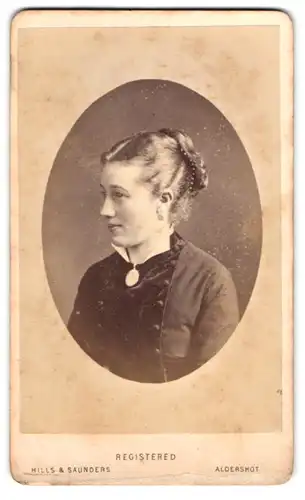 Fotografie Hills & Saunders, Aldershot, Hübsche junge Dame mit gebundenem Haar in schwarzem Kleid
