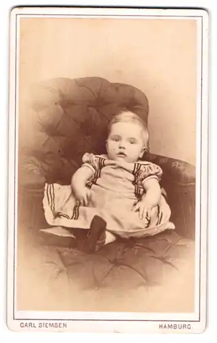 Fotografie Carl Siemsen, Hamburg, Steindamm 157, Kleinkind im Kleidchen auf dem Sofa