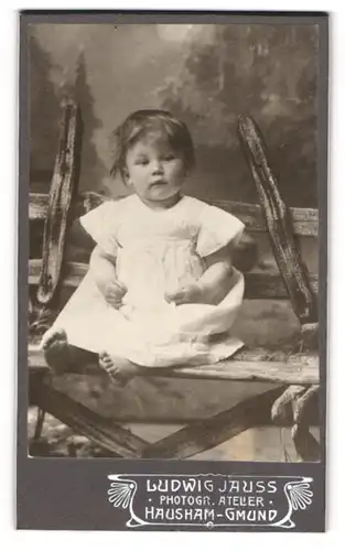 Fotografie Ludwig Jauss, Hausham-Gmund, Kleinkind im Sommerkleidchen auf einer Bank