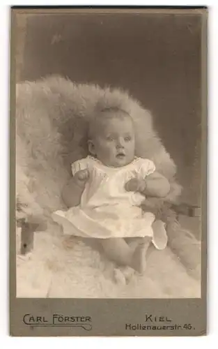 Fotografie Carl Förster, Kiel, Holtenauer Str. 46, Süsses Kleinkind im Hemd sitzt auf einem Fell