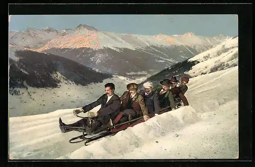 AK Sechs Herren auf dem Schlitten vor herrlichem Bergpanorama