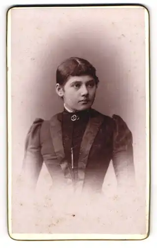 Fotografie Würthle & Spinnhirn, Salzburg, Schwarzstrasse 9, Junge Dame mit Ringbrosche im eleganten schwarzen Kleid