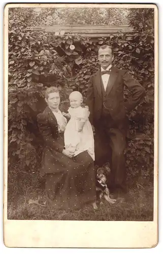 Fotografie unbekannter Fotograf und Ort, Paar mit Kind und Hund im Garten